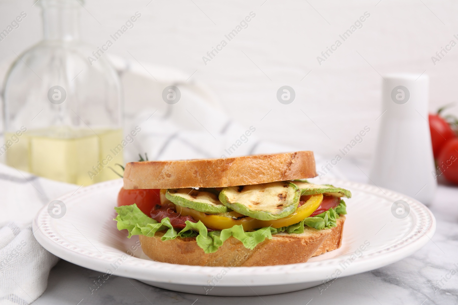 Photo of Tasty sandwich with grilled vegetables on white marble table, closeup