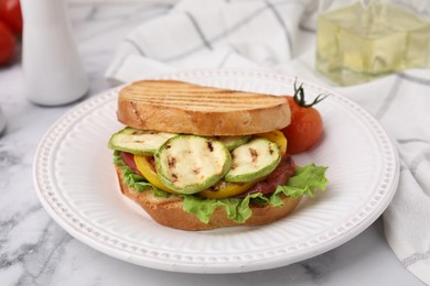 Photo of Tasty sandwich with grilled vegetables on white marble table, closeup