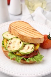 Photo of Tasty sandwich with grilled vegetables on table, closeup