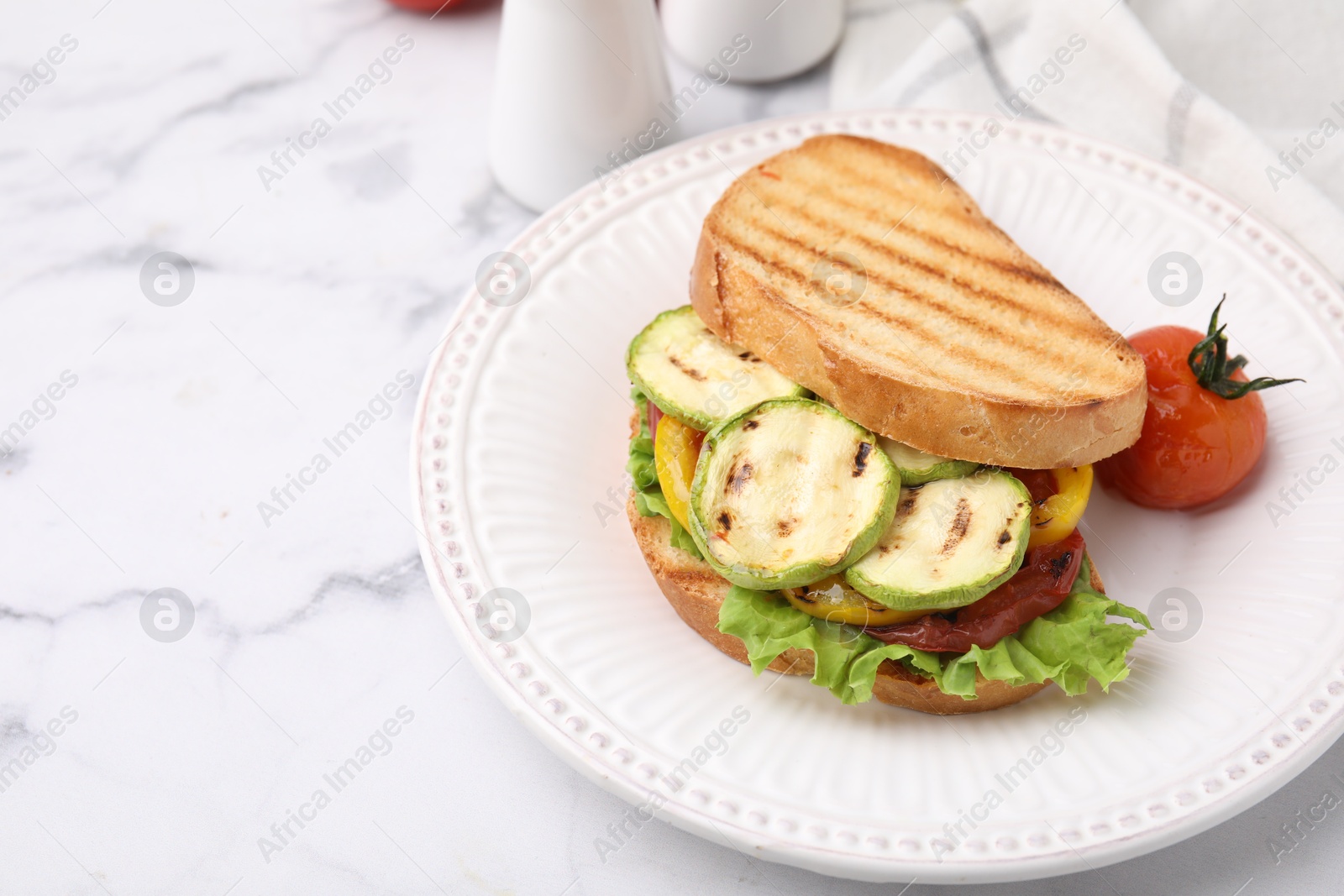 Photo of Tasty sandwich with grilled vegetables on white marble table, closeup. Space for text