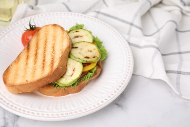 Photo of Tasty sandwich with grilled vegetables on white marble table, closeup. Space for text