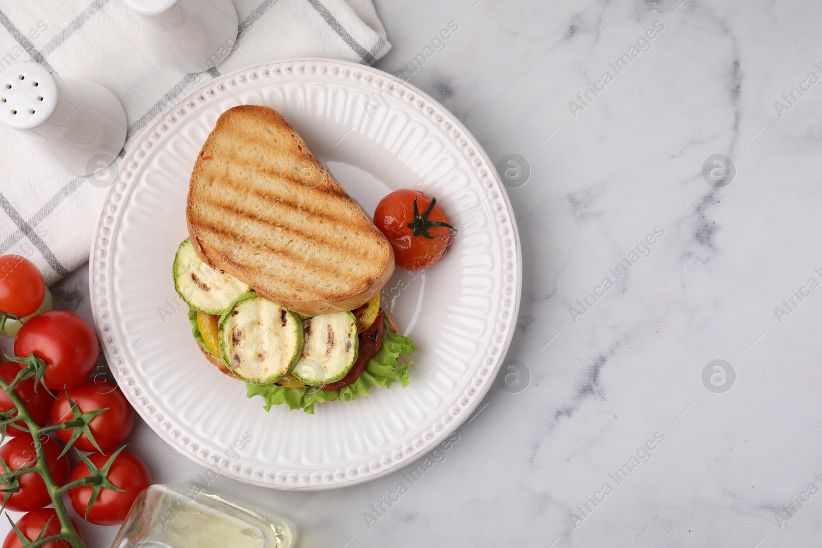 Photo of Tasty sandwich with grilled vegetables, fresh tomato and spices on white marble table, flat lay. Space for text