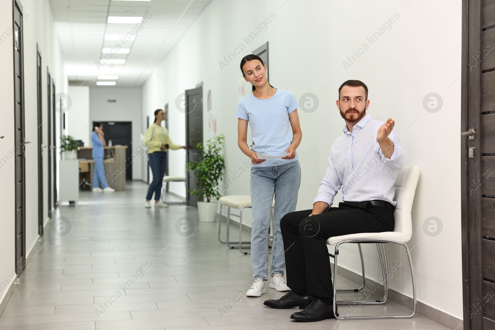 Photo of Patients waiting for appointment and doctor in hospital hallway, selective focus