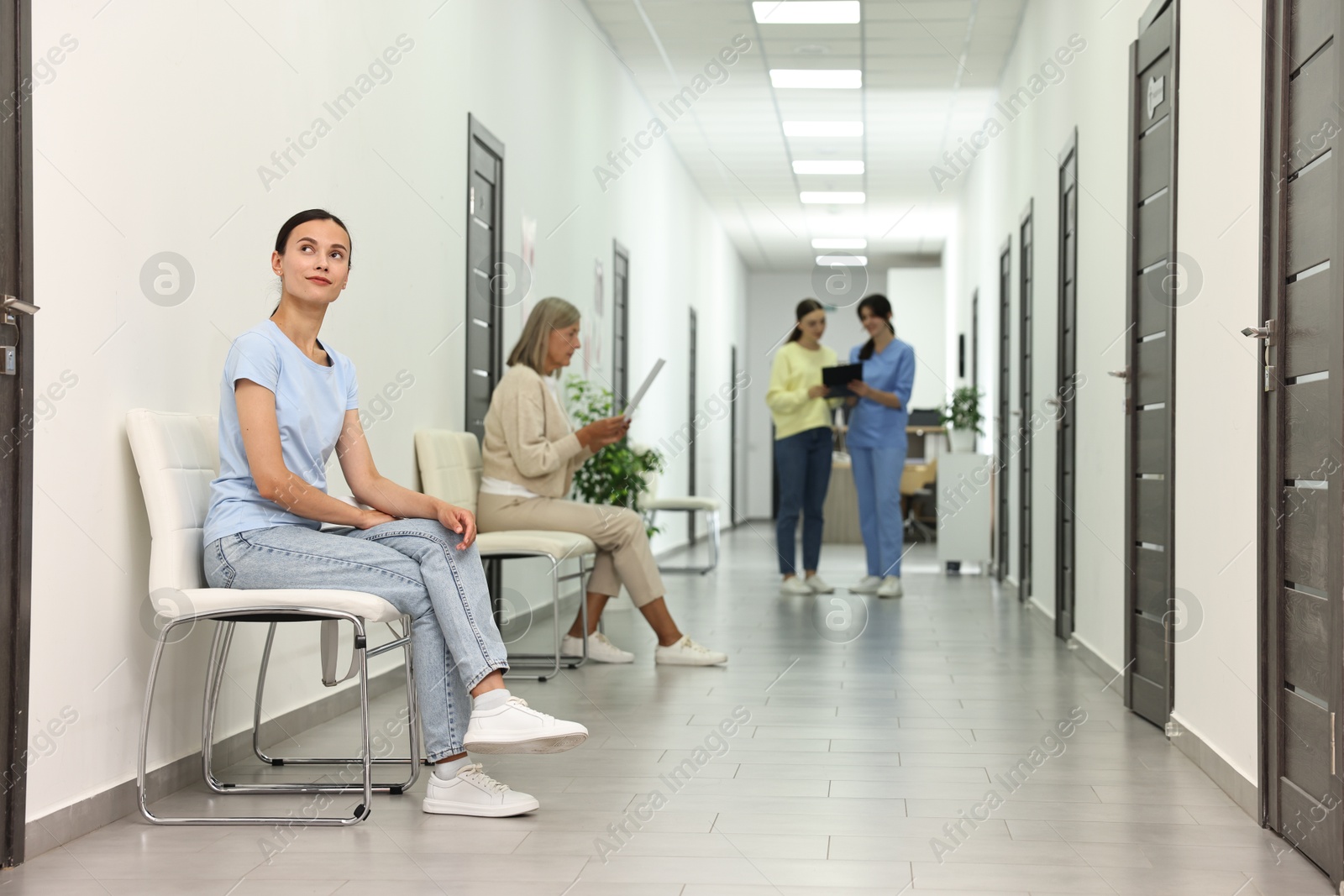 Photo of Patients waiting for appointment and doctor in hospital hallway, selective focus