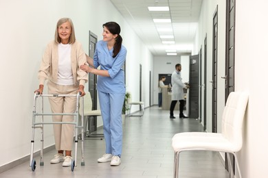 Nurse with senior woman in hospital hallway