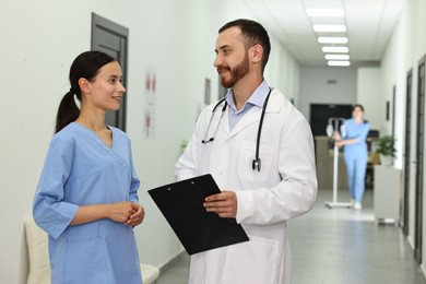 Doctor and nurse talking in hospital hallway