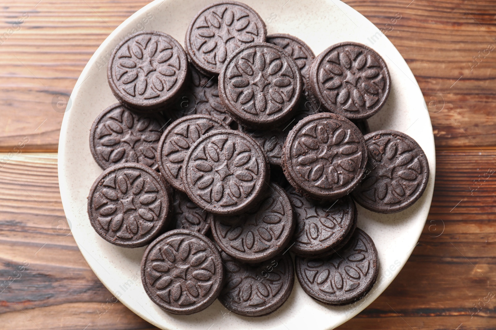 Photo of Many tasty sandwich cookies on wooden table, top view