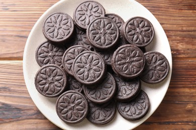 Many tasty sandwich cookies on wooden table, top view