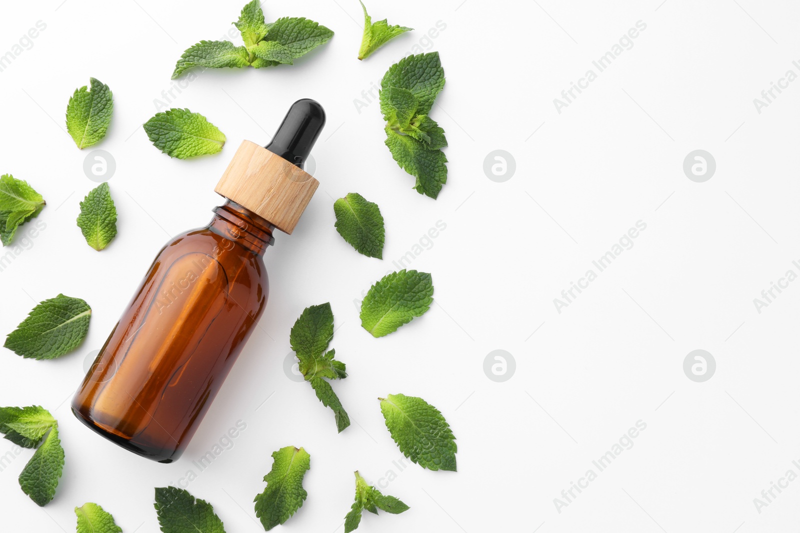 Photo of Bottle of essential oil and mint isolated on white, top view