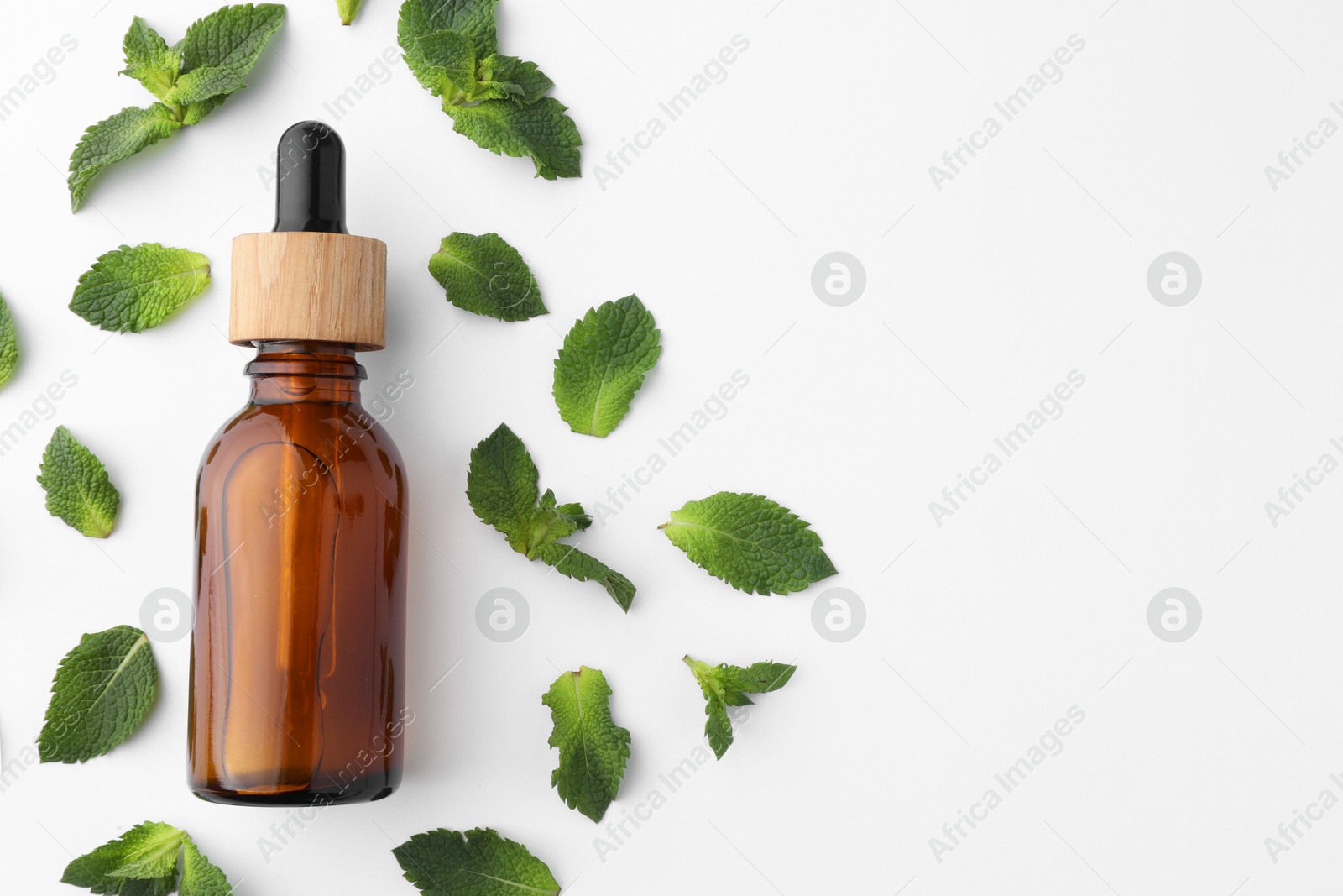 Photo of Bottle of essential oil and mint isolated on white, top view