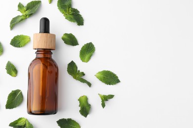 Photo of Bottle of essential oil and mint isolated on white, top view