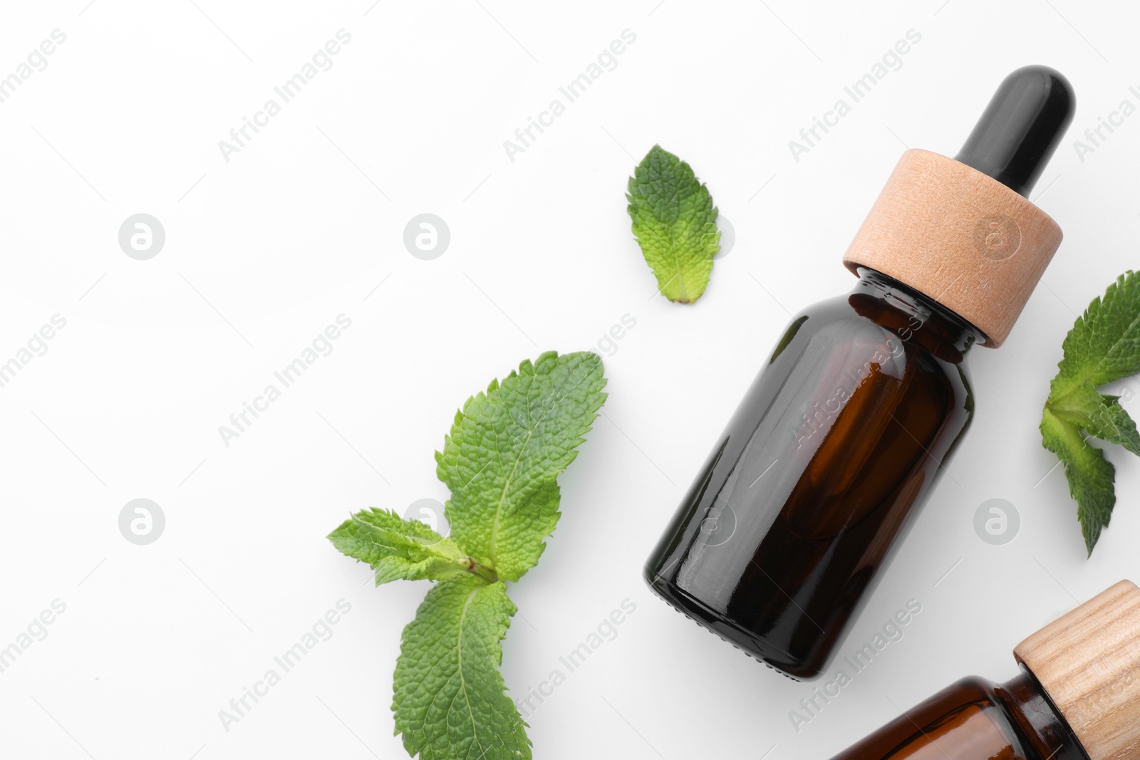 Photo of Bottles of essential oils and mint isolated on white, top view