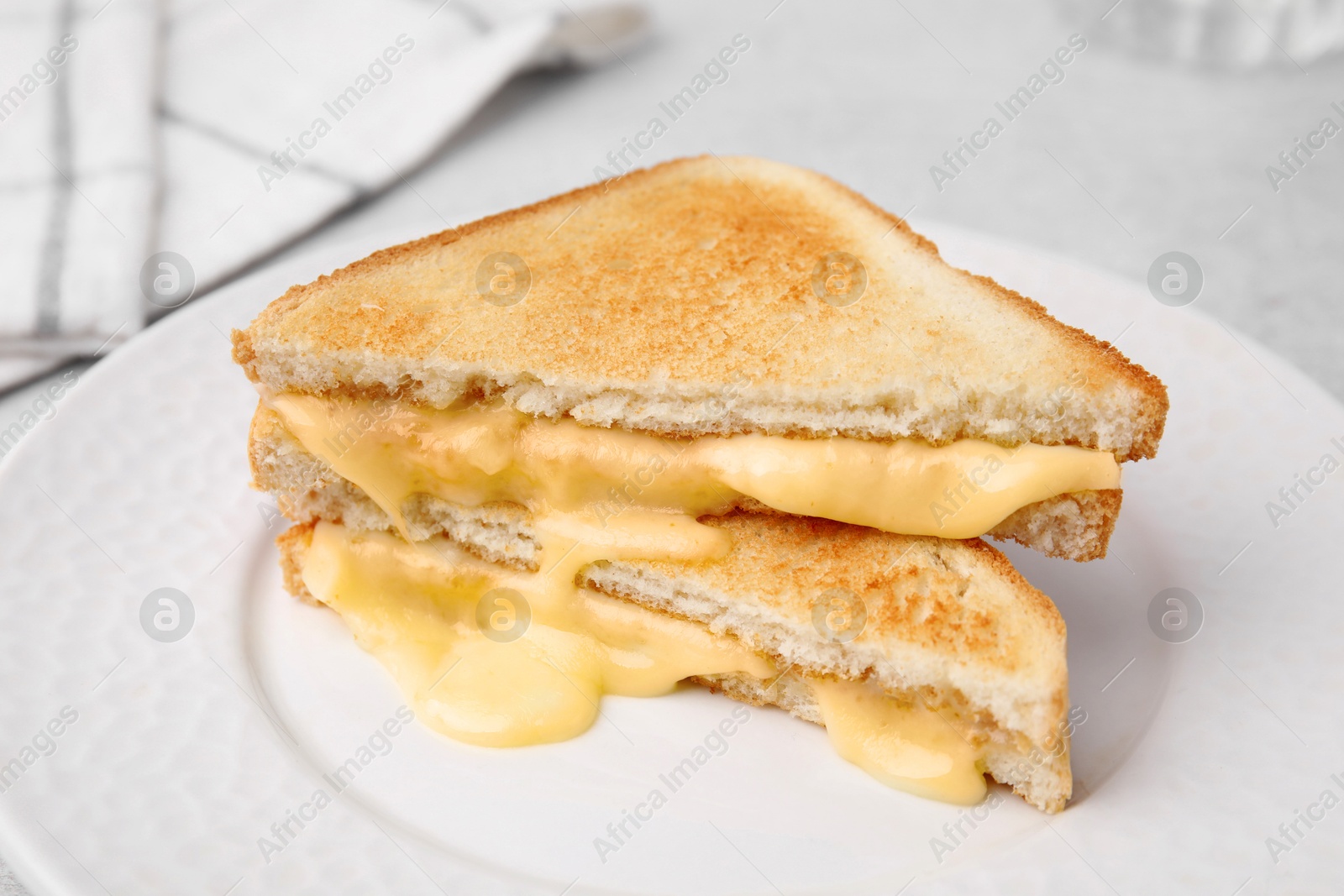 Photo of Pieces of toasted bread with melted cheese on table, closeup