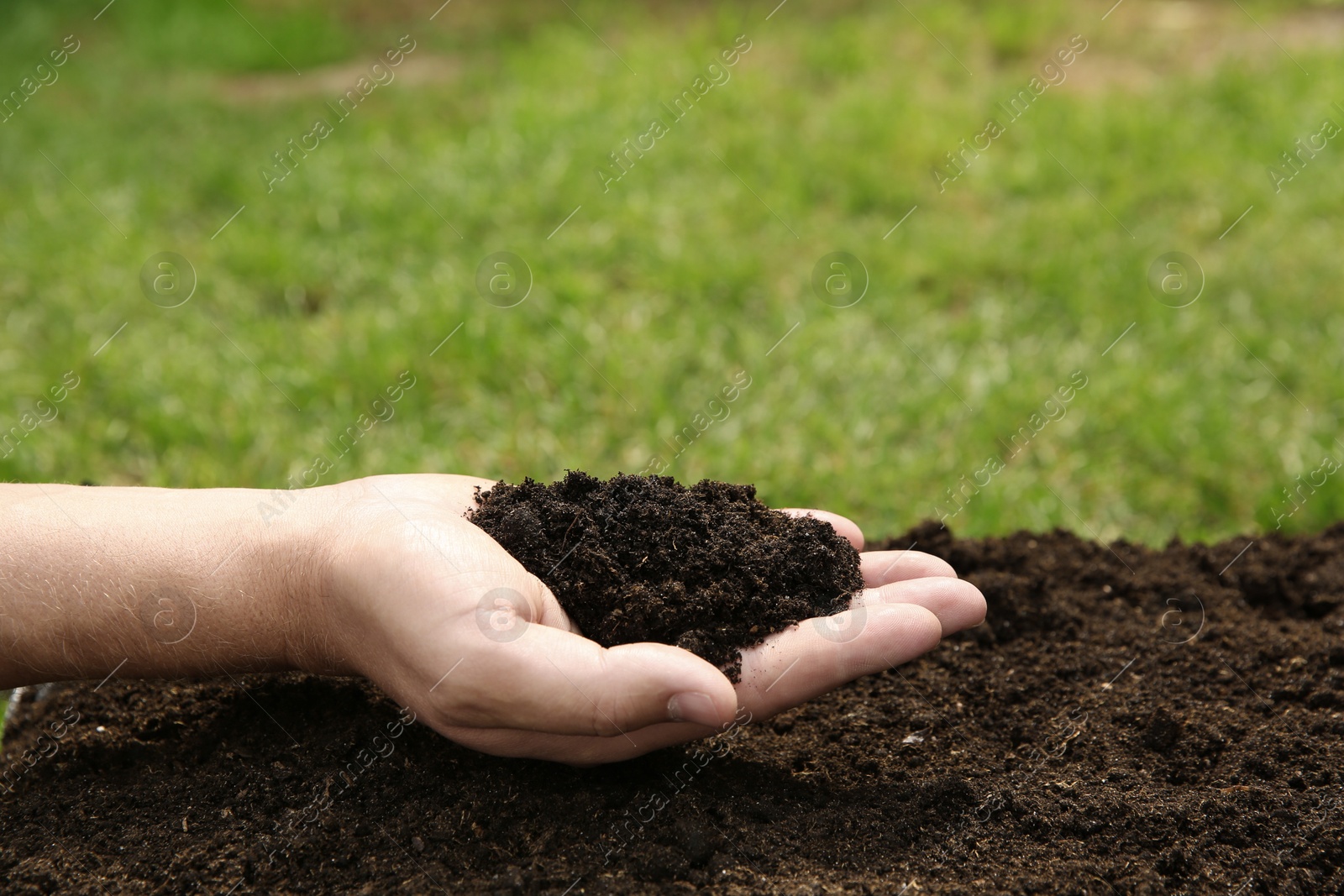 Photo of Woman holding pile of soil outdoors, closeup. Space for text