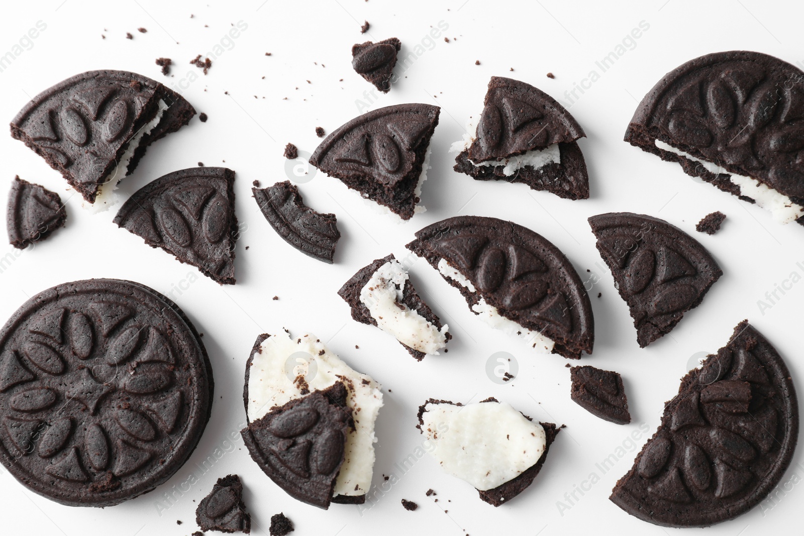 Photo of Whole and broken tasty sandwich cookies on white background, flat lay