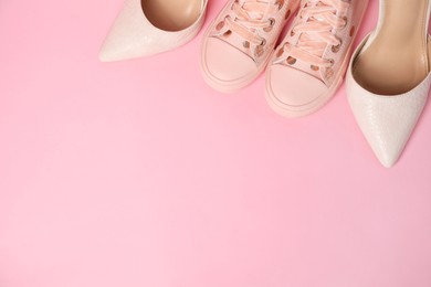 Photo of Big and small shoes on pink background, top view. Space for text