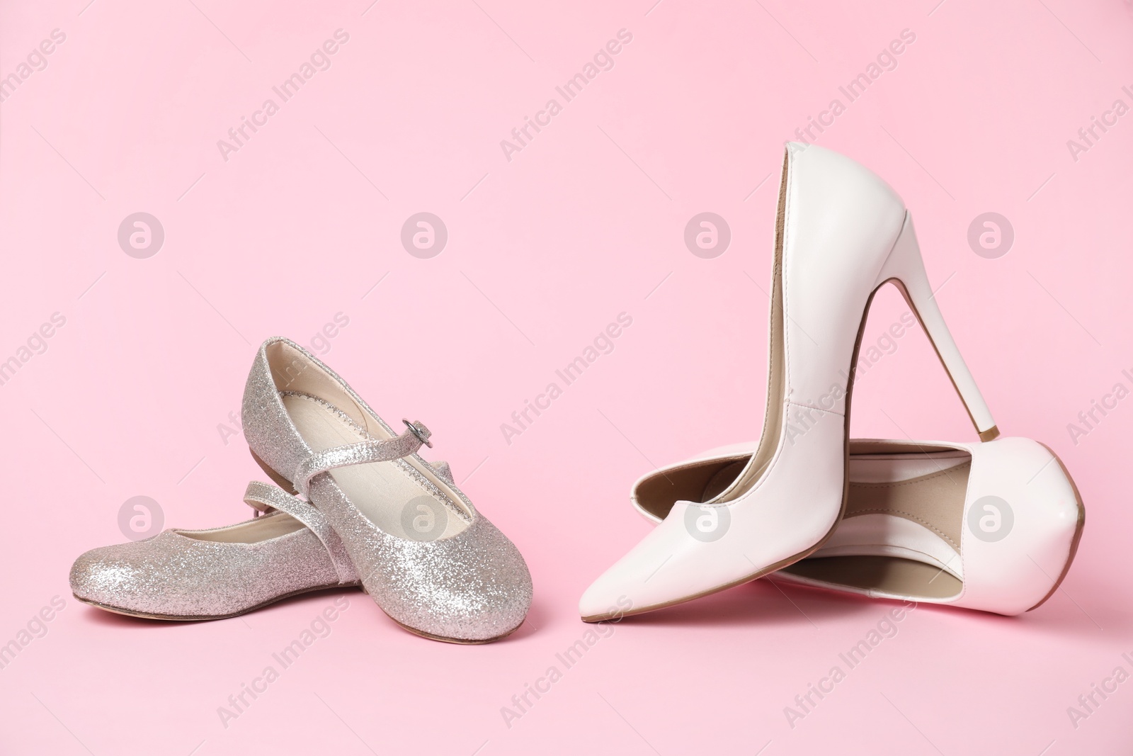 Photo of Big and small shoes on pink background