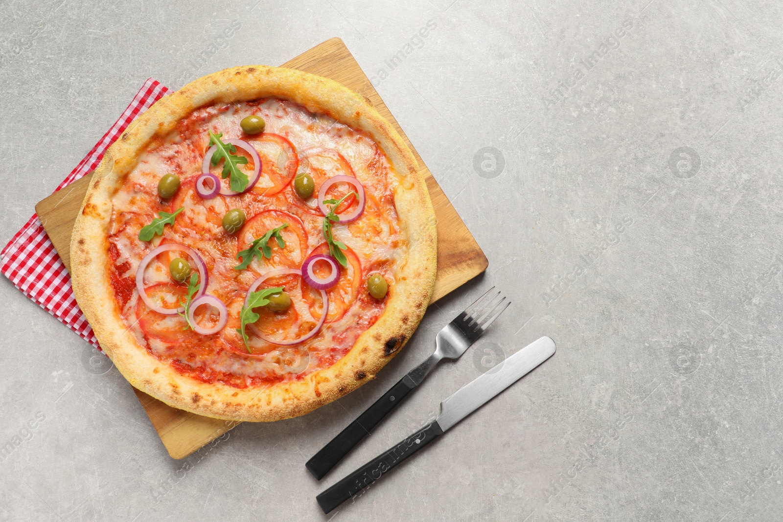 Photo of Delicious vegetarian pizza and cutlery on light grey background, top view. Space for text