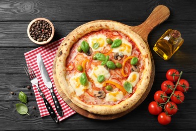 Photo of Delicious vegetarian pizza served on black wooden table, top view