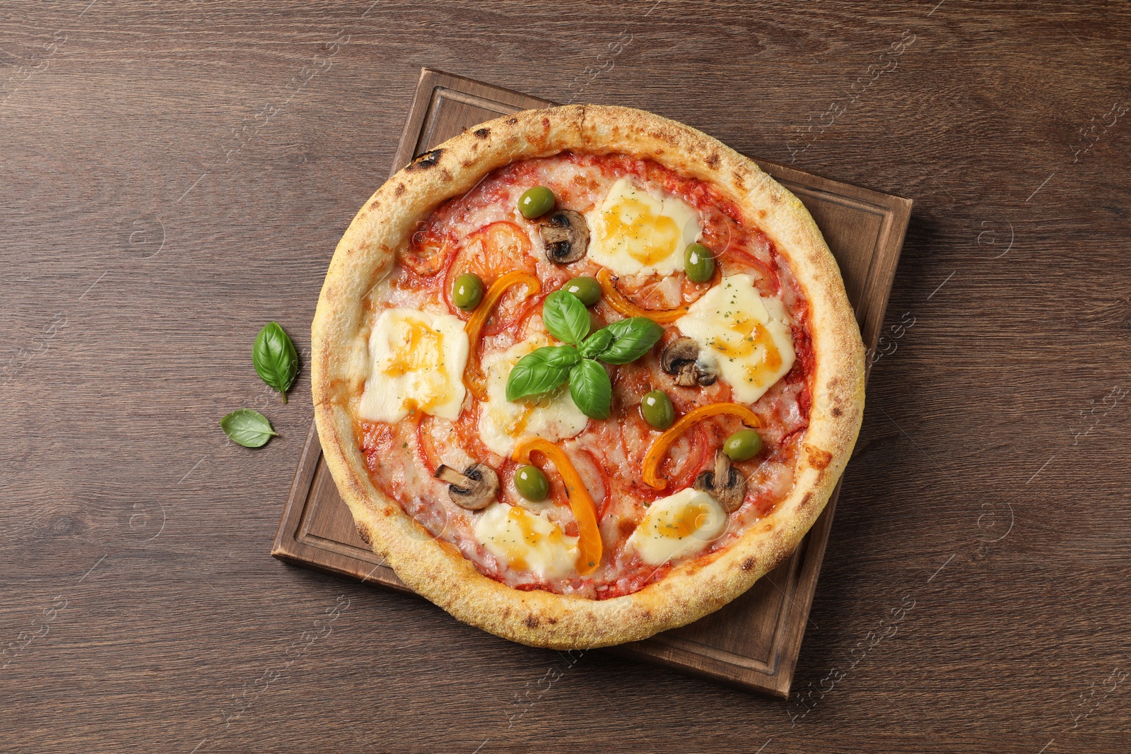 Photo of Delicious vegetarian pizza on wooden table, top view