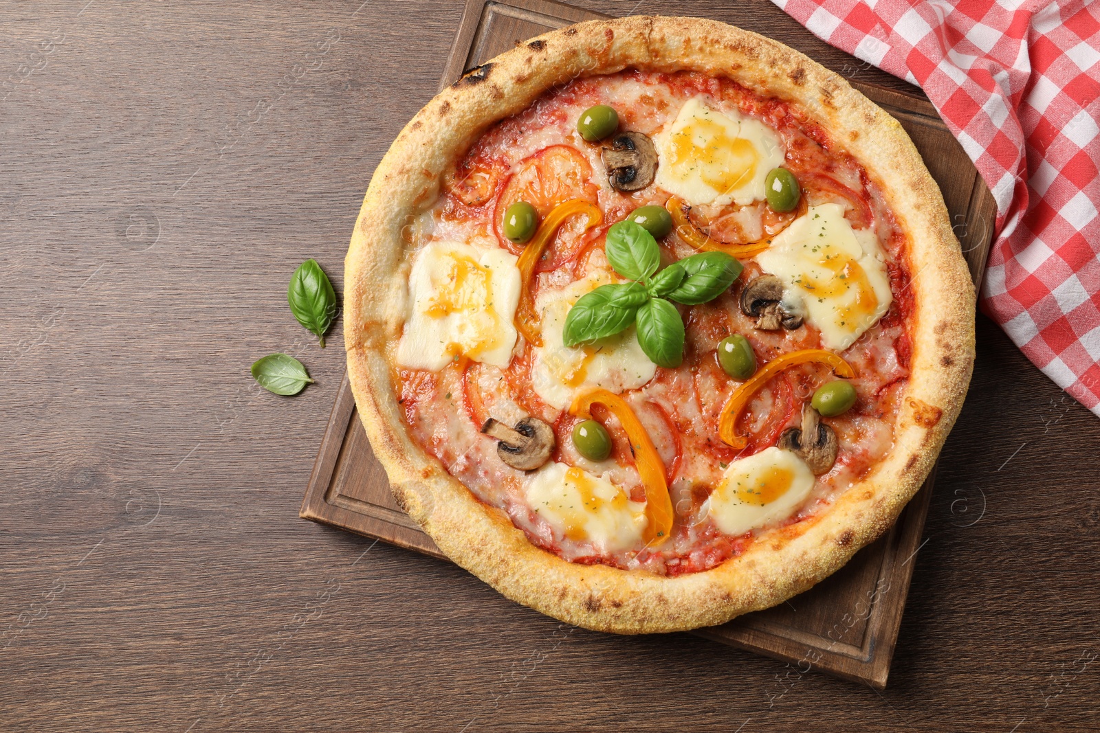 Photo of Delicious vegetarian pizza on wooden table, top view