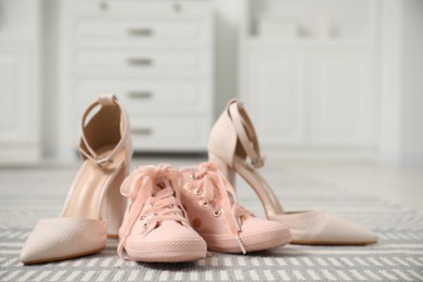 Big and small shoes on carpet indoors