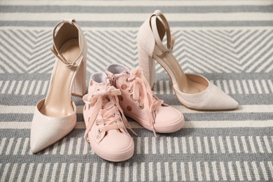 Photo of Big and small shoes on carpet indoors