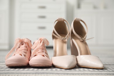 Big and small shoes on carpet indoors