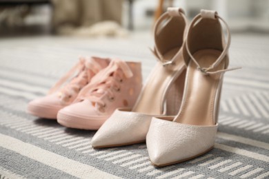 Photo of Big and small shoes on carpet indoors