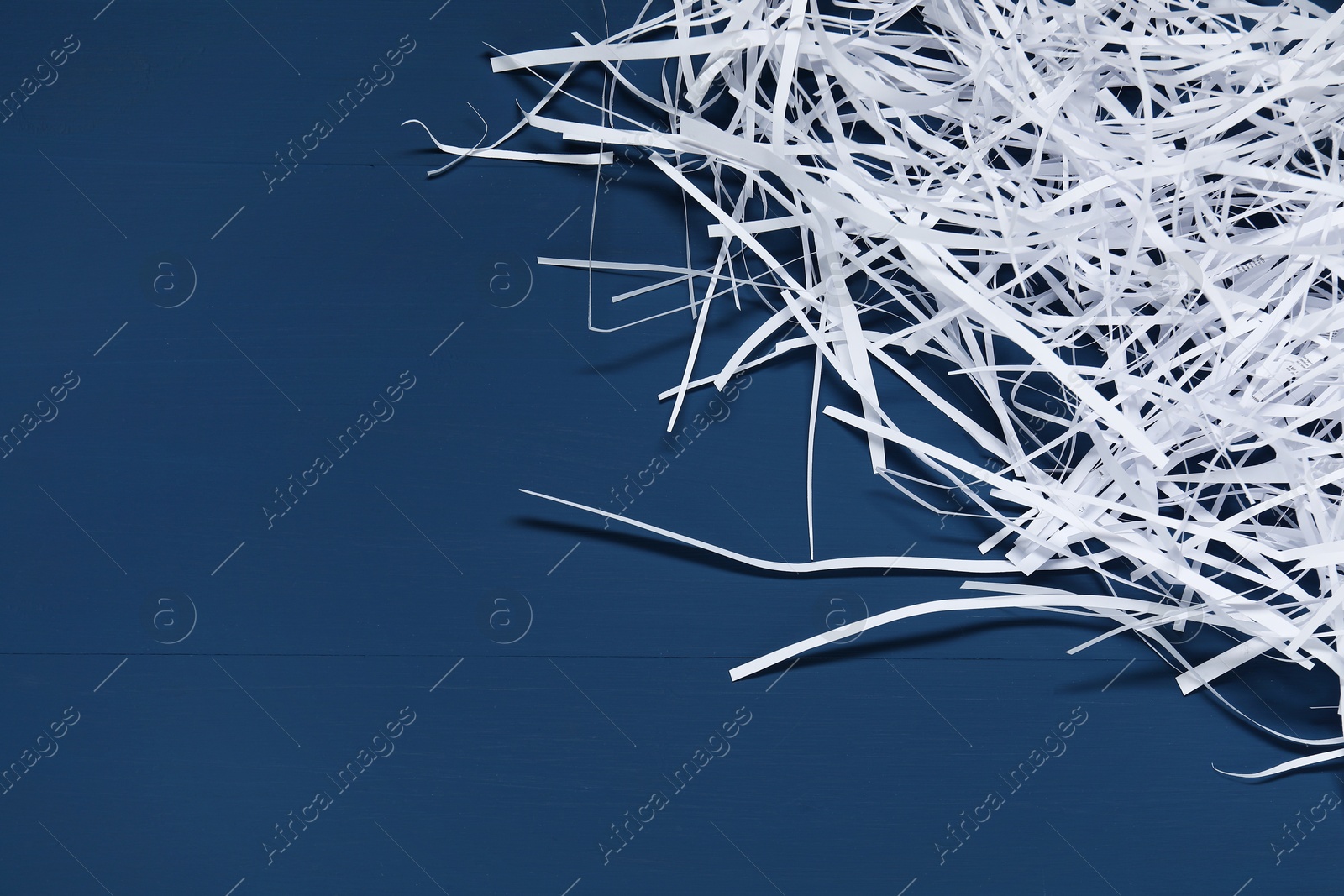 Photo of Paper strips on blue wooden table, top view. Space for text