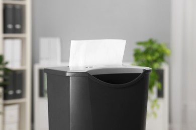 Photo of Destroying sheets of paper with shredder in office