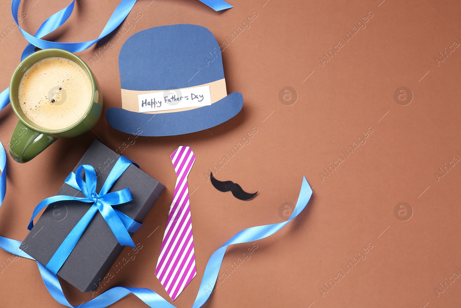 Photo of Paper hat with phrase Happy Father's Day, coffee and gift on brown background, flat lay