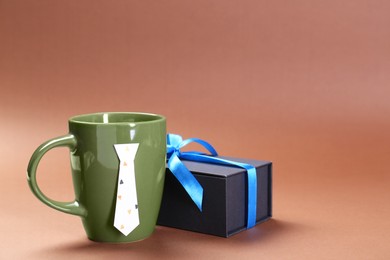 Photo of Happy Father's Day. Coffee and gift on brown background