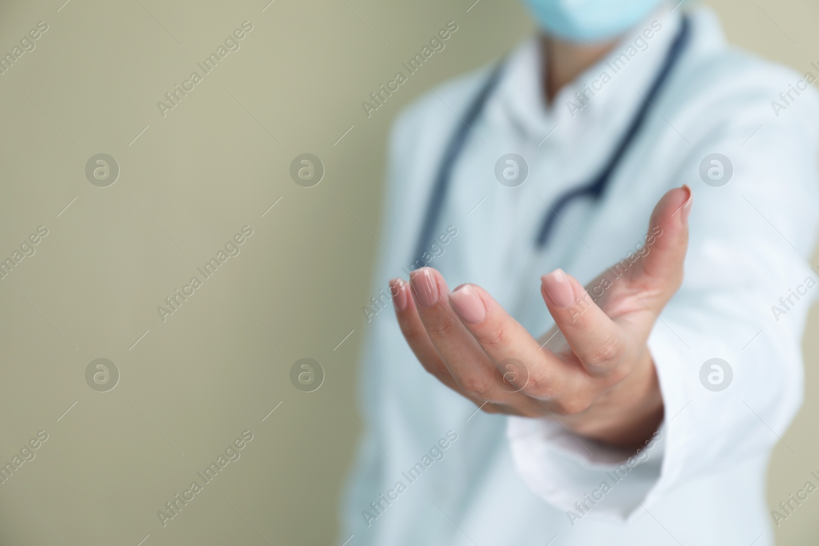 Photo of Doctor holding something on beige background, closeup. Space for text