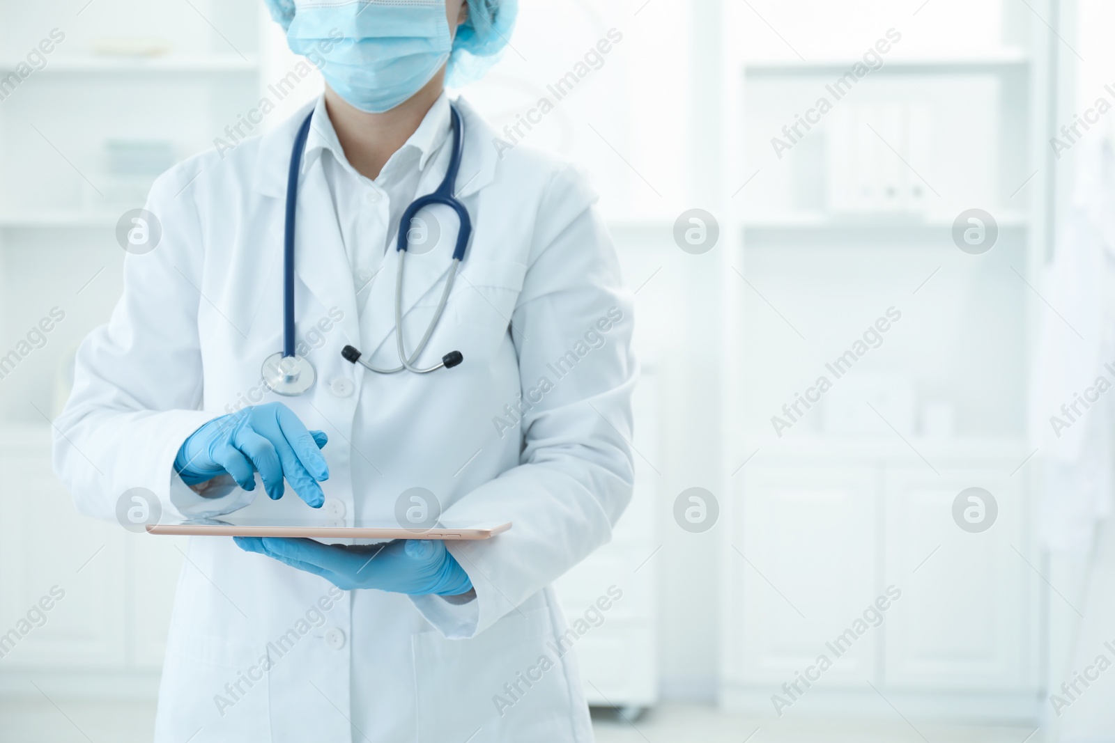 Photo of Doctor with tablet in clinic, closeup view. Space for text