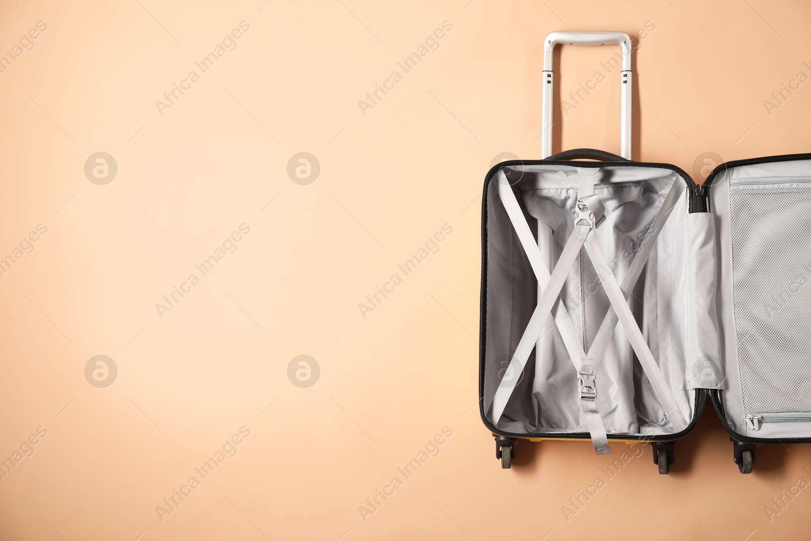 Photo of Open empty suitcase on beige background, top view. Space for text