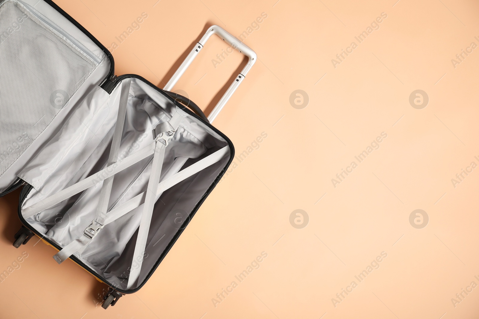 Photo of Open empty suitcase on beige background, top view. Space for text