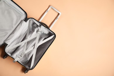 Photo of Open empty suitcase on beige background, top view. Space for text