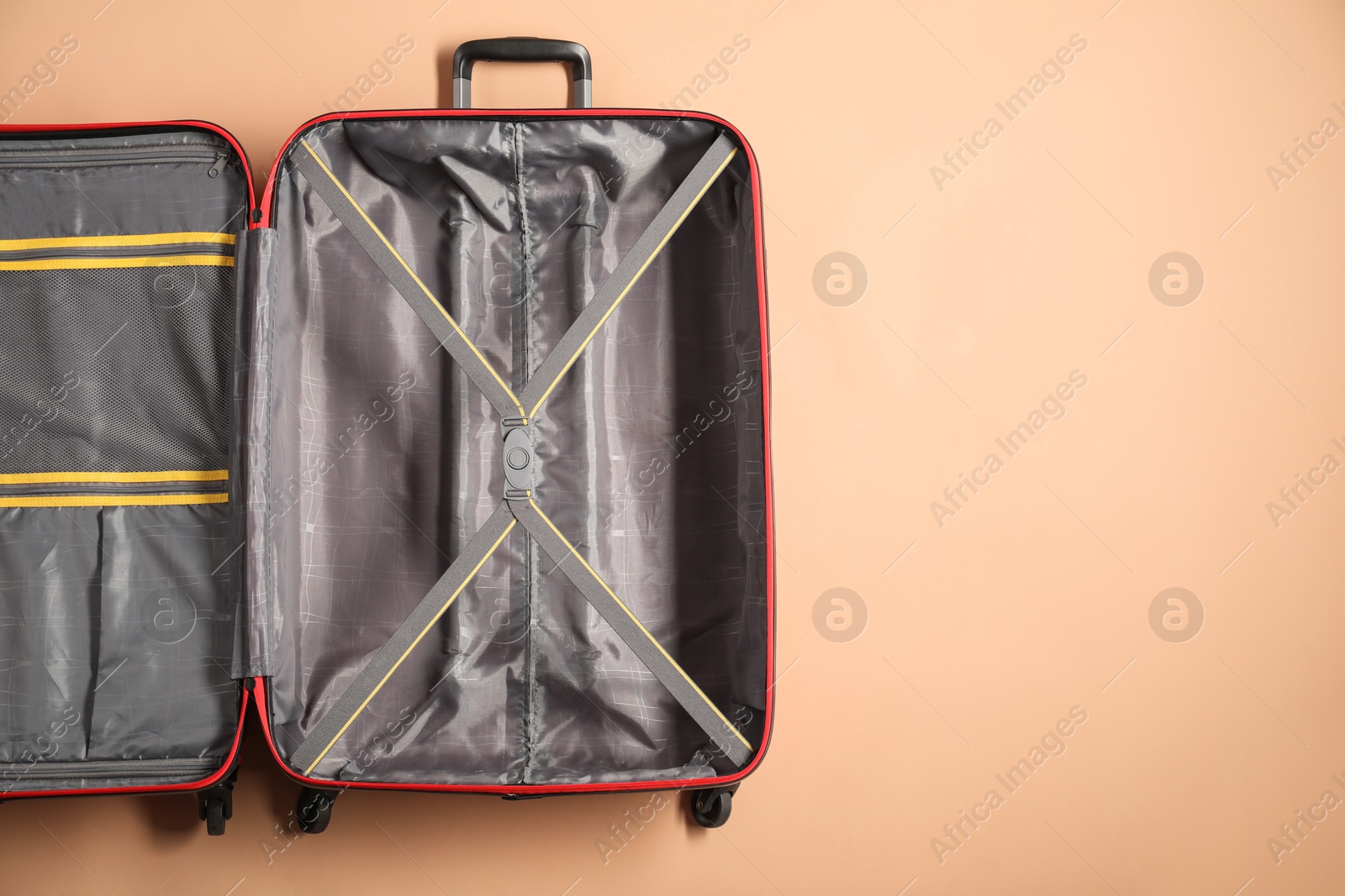 Photo of Open empty suitcase on beige background, top view. Space for text