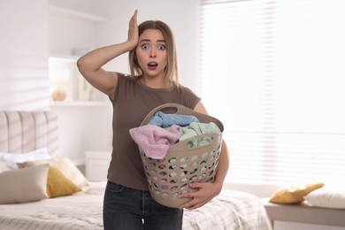 Emotional housewife with basket full of laundry at home