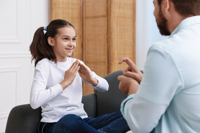 Man and his daughter using sign language for communication at home