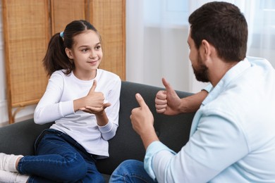 Man and his daughter using sign language for communication at home