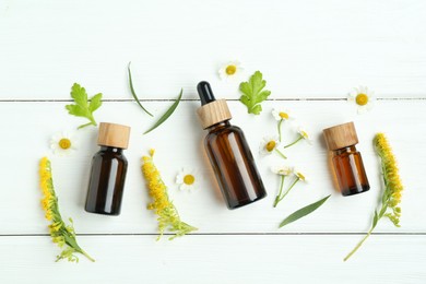 Photo of Tinctures in bottles, goldenrods and chamomile flowers on white wooden table, flat lay