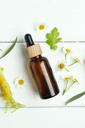 Photo of Tincture in bottle, goldenrod flower and chamomiles on white wooden table, flat lay