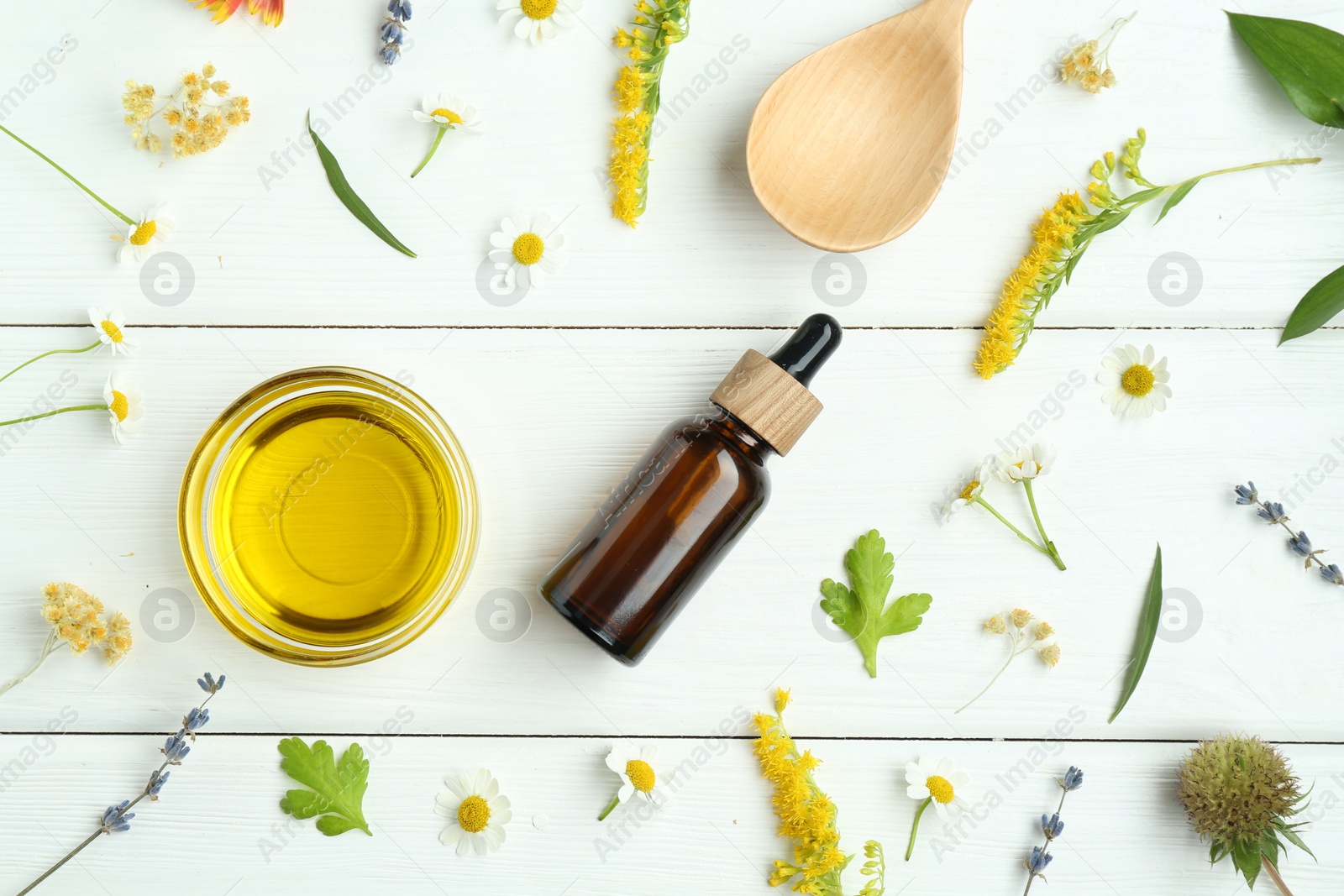 Photo of Tinctures and medicinal herbs on white wooden table, flat lay