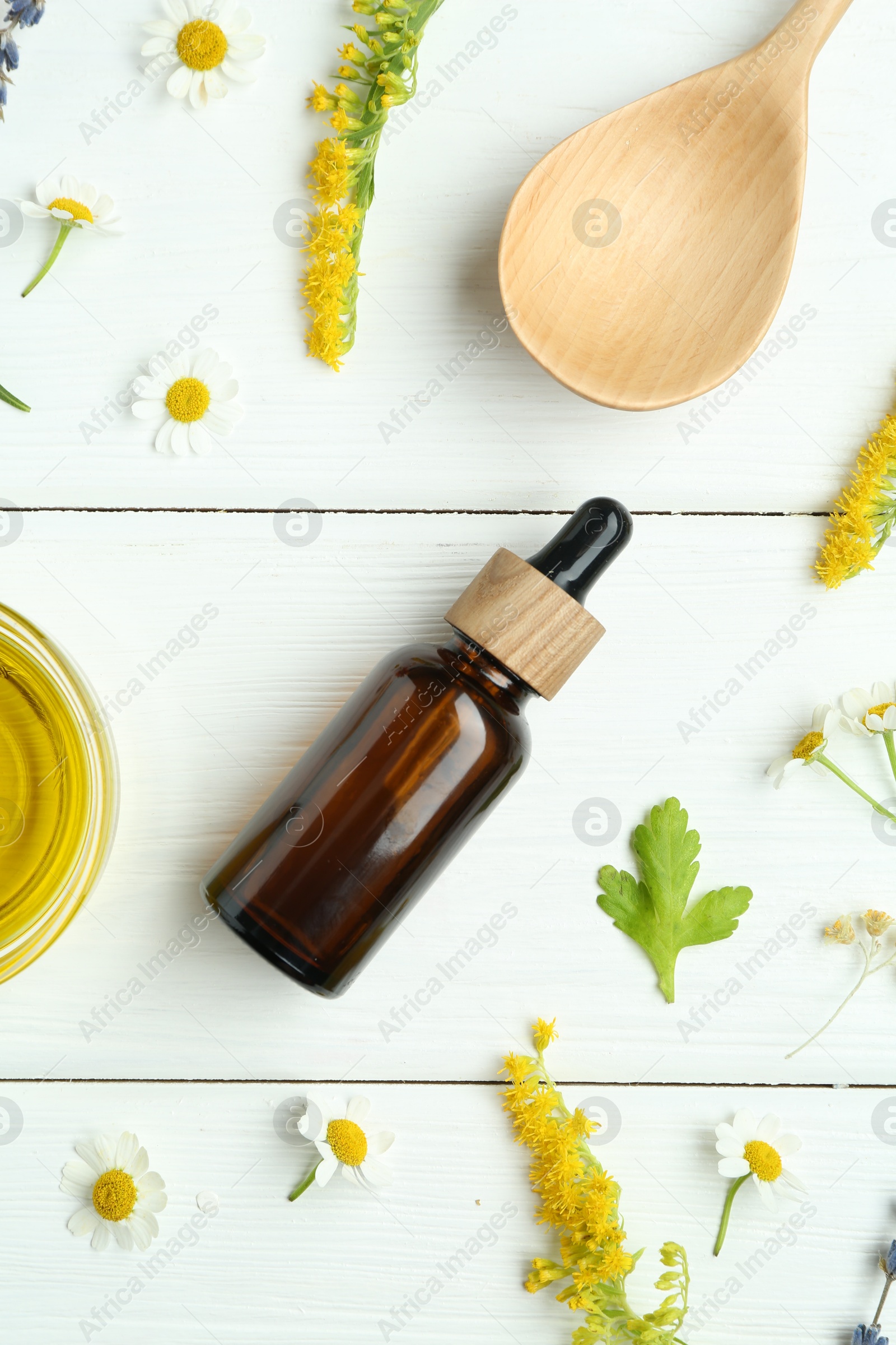 Photo of Tinctures and medicinal herbs on white wooden table, flat lay