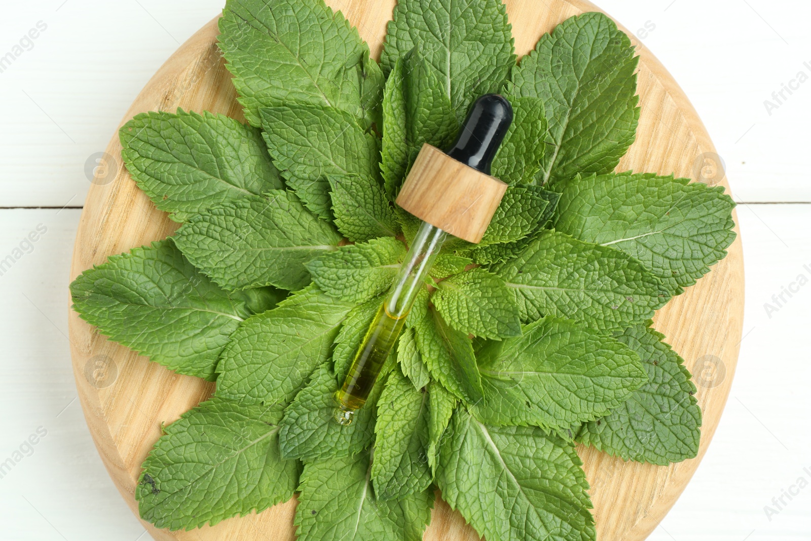 Photo of Pipette with tincture and mint on white wooden table, top view