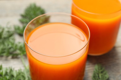 Healthy carrot juice in glasses on table, closeup