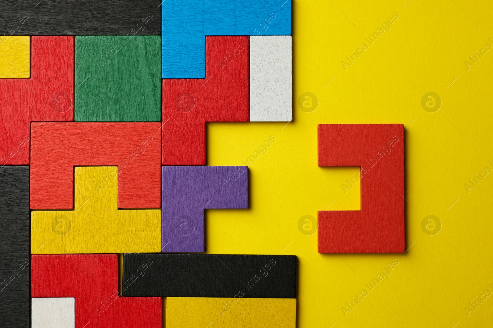 Photo of Colorful wooden puzzle pieces on yellow background, top view