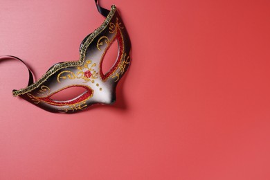 Beautiful carnival mask on red background, top view. Space for text